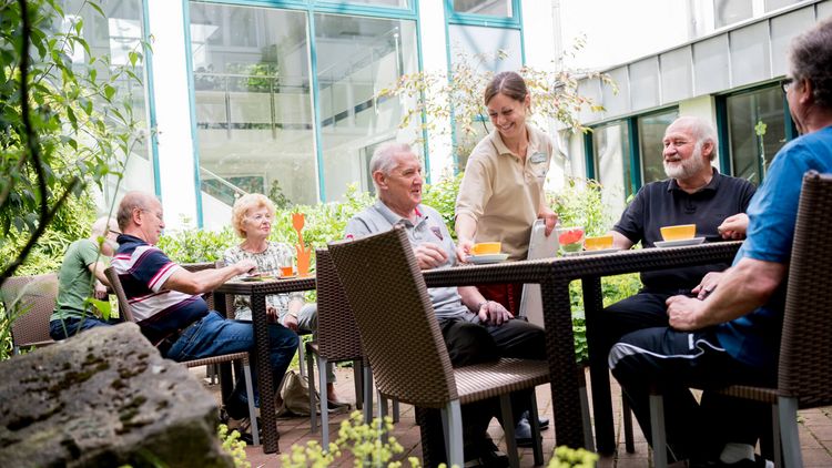 Patienten trinken draußen eine Tasse Kaffee