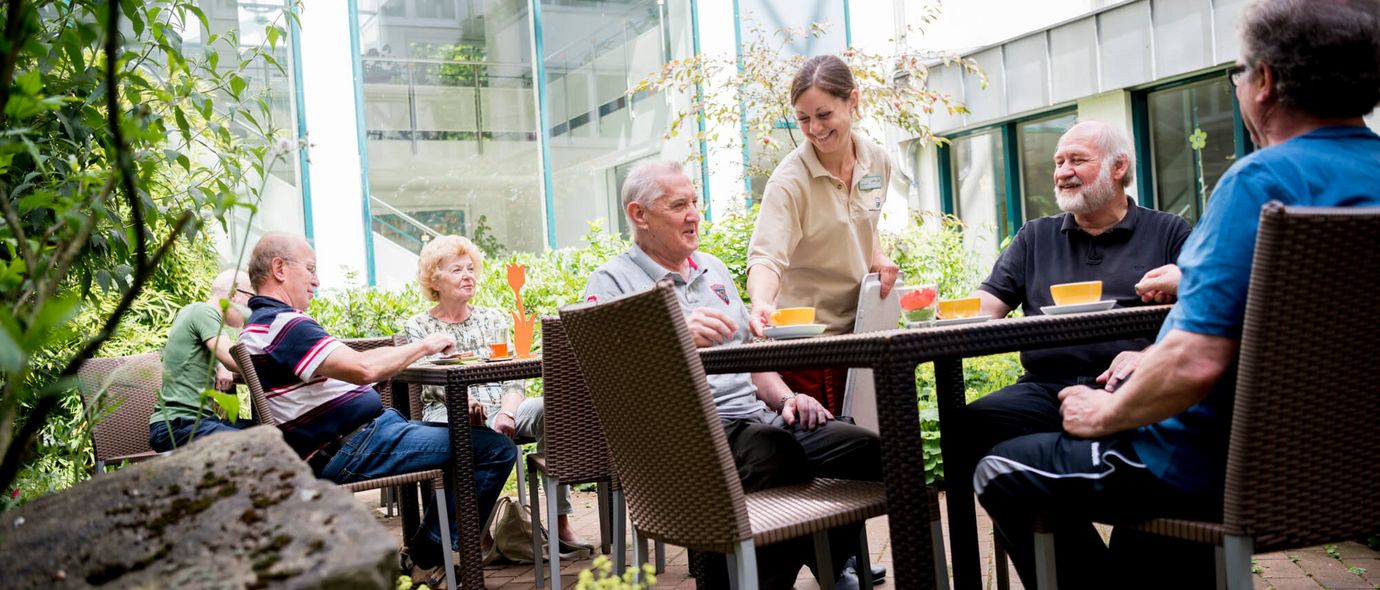 Patienten trinken draußen eine Tasse Kaffee