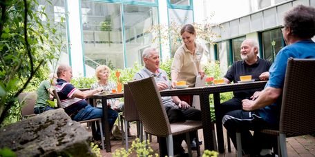 Patienten trinken draußen eine Tasse Kaffee