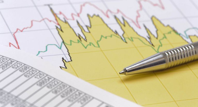 Kugelschreiber liegt auf Papieren mit Grafiken und Zahlen