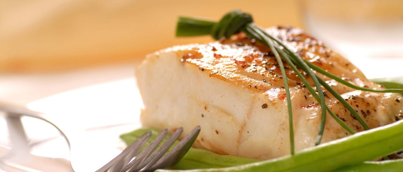Gabel liegt neben Fischfielt in Sauce