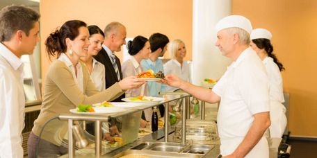Köche servieren Essen in einer Kantine